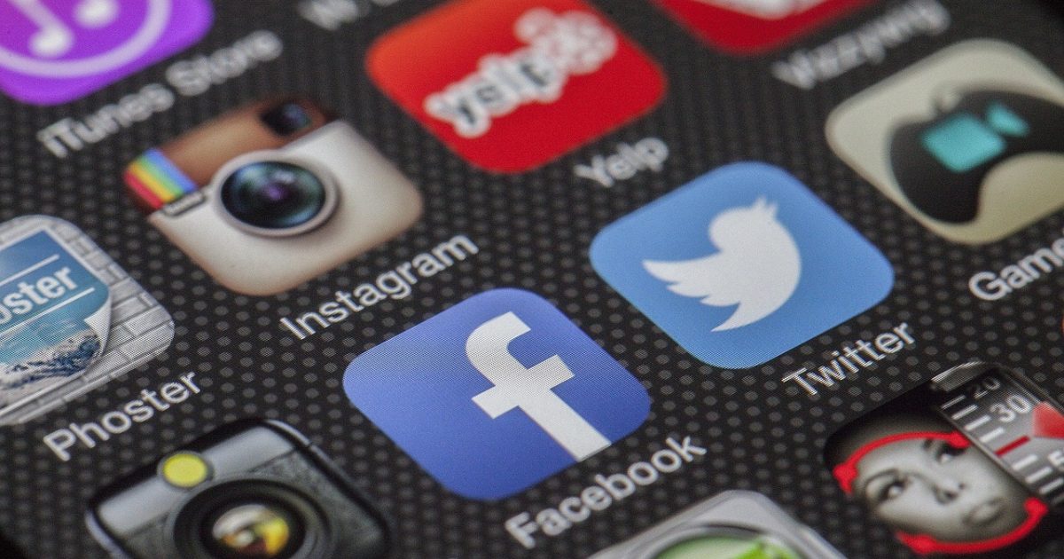 al风月 App 主界面在手机屏幕上展开，蓝紫渐变背景中的玻璃质感卡片整齐排列，桌面暖光映出柔和反光